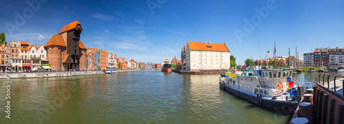 Panorama of the old town in Gdansk with historical port crane reflected in Motlawa river, Poland