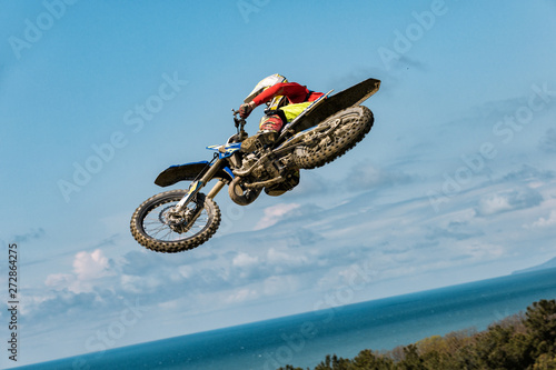 A picture of a biker making a stunt and jumps in the air