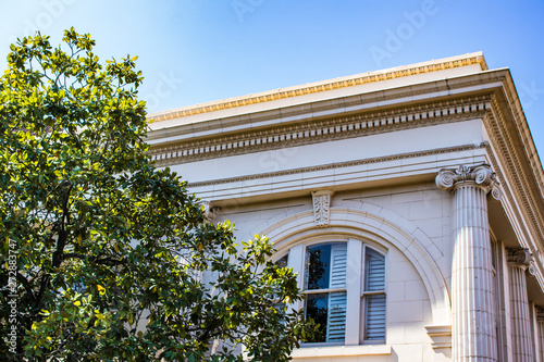 A Magnolia Tree Growing in front of a Traditional Cream Colored Building with Beautiful Columns in the French Quarter of New Orleans, Louisiana, USA