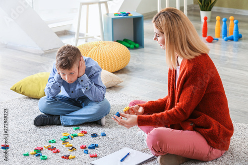 Female psychologist working with boy suffering from autistic disorder