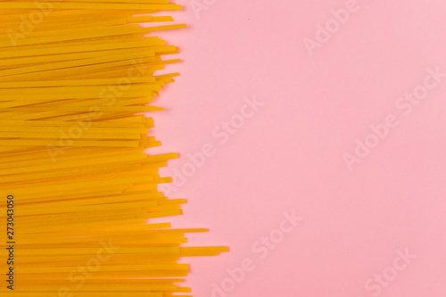 Spaghetti pasta on a pink background