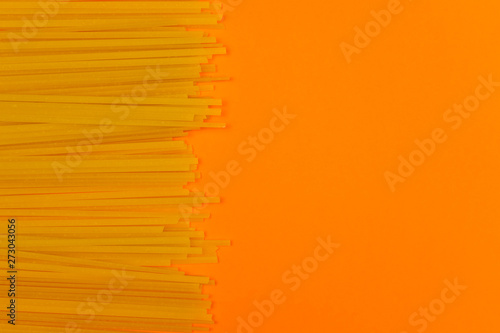 Pasta noodles on orange background