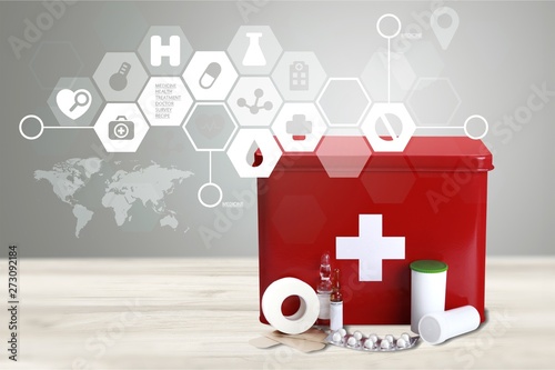First aid kit with medical supplies on light background