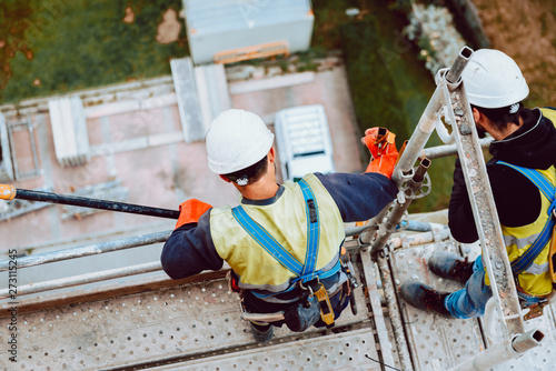 workers work removing a scaffolding at high altitude in Oviedo, Asturias, Spain.