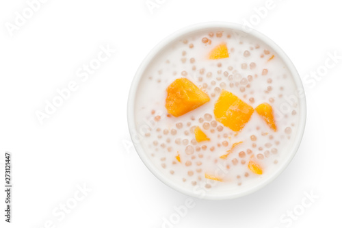 A bowl of sweet sago cream with mango and coconut milk on white background.Top view.