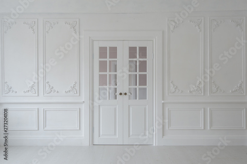 Luxurious bright interior of the living room in Baroque style with stucco and double door.