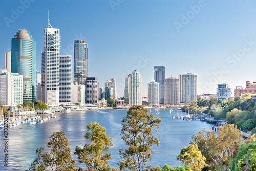 Huge city with tall buildings among trees and river