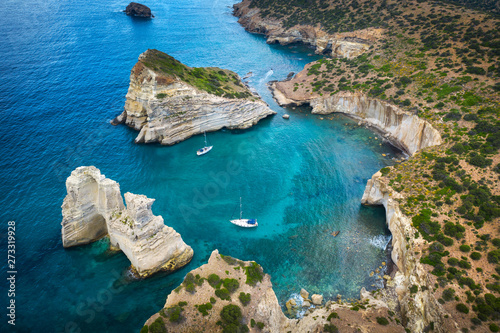 aerial view to curved rock bay with giant rocks and two yachts in Greece