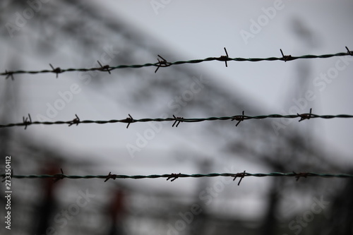 barbed wire with the blurred background of a refugee camp