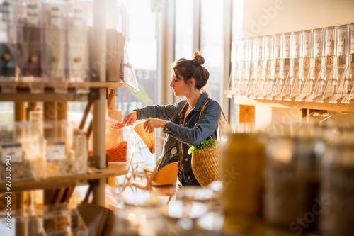 Beautiful young woman shopping in a bulk food store.