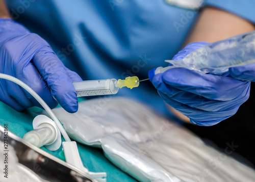 Nurse preparing medication for parenteral nutrition in a hospital, conceptual image