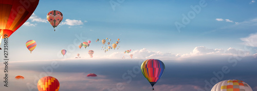 Viele Heißluftballons fliegen über den Wolken