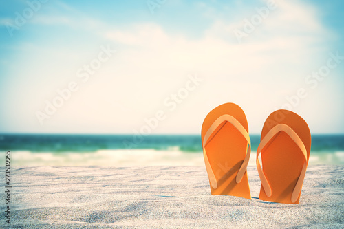 Orange flip flops on beach