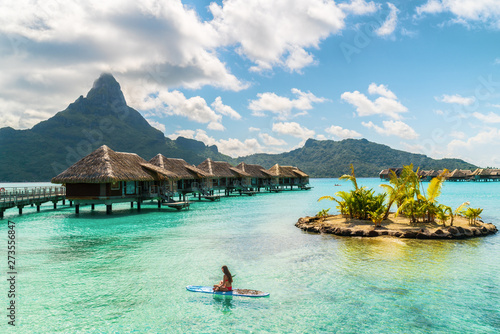 Tahiti luxury resort hotel in Bora Bora ,French Polynesia. Paddleboard leisure activity SUP paddle woman on active vacation in Tahiti, French Polynesia. Mount Otemanu summer holiday.