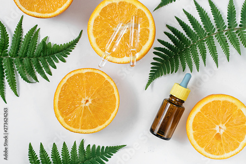 Citrus essential oil, vitamin c serum with fresh juicy orange fruit and leaf fern on white background. Organic Spa Cosmetic With Herbal Ingredients Toning. High dose vitamin c synthetic for skin