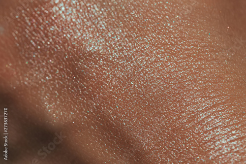 texture of human skin with liquid highlighter swatch