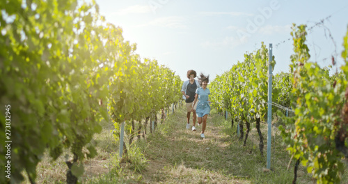 Romantic love couple walking and playful running thru green vineyards. Front follow wide shot.Friends italian trip in Umbria.4k slow motion