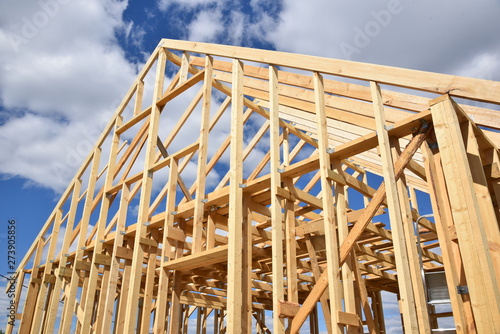 Wood frame residential building under construction.Building construction, wood framing structure at new property development site.new home currently under construction against blue sky.mortgage, loan.