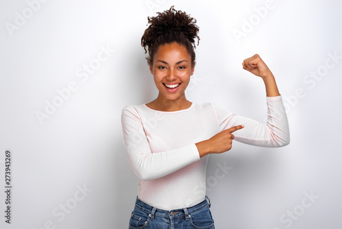 Funny girl pointing to an herself biceps smiling looking at the camera