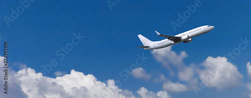 Commercial passenger aircraft in white colour. Blue cloudy sky in the background