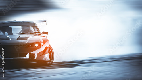 Dryfowanie samochodu, rozmazany samochód wyścigowy z rozmyciem obrazu z dużą ilością dymu z płonących opon na torze prędkości
