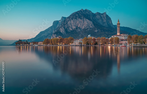 The city of Lecco on Lake Como with reflections in the water during a blue hour in an autumn day