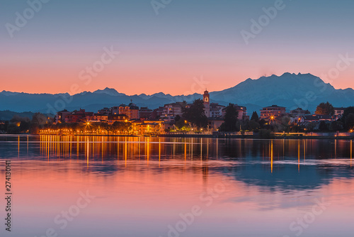 Sesto Calende on Ticino River next to Lake Maggiore after the sunset with city reflectionss