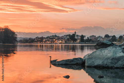 Sesto Calende on Ticino River next to Lake Maggiore at sunset with orange sky