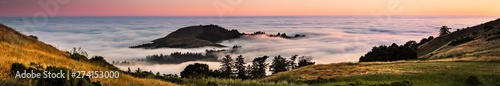 Panoramic view at sunset of valley covered in a sea of clouds in the Santa Cruz mountains, San Francisco bay area, California