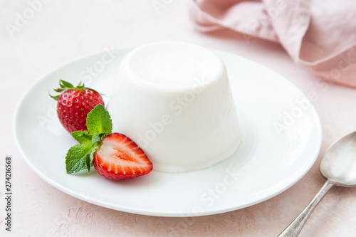 Panna cotta, traditional italian dessert, served with fresh strawberry and mint