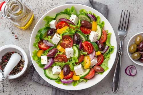 fresh greek salad ( tomato, cucumber, bel pepper, olives and feta cheese) in white bowl