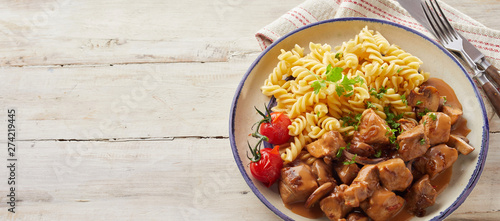 Fusilli pasta and sliced meat inside bowl