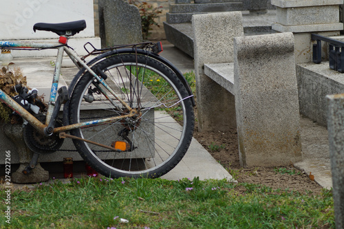 Auf einem Grabstein angelehntes Fahrrad