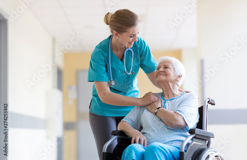 Senior woman in wheelchair with nurse in hospital