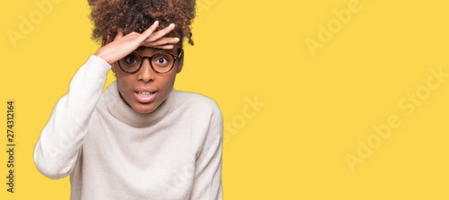 Beautiful young african american woman wearing glasses over isolated background very happy and smiling looking far away with hand over head. Searching concept.