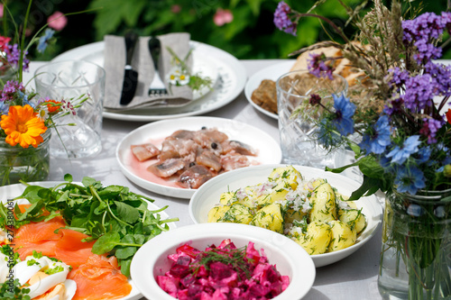 Scandinavian midsummer feast with potato salad, herring, salmon and beetroot