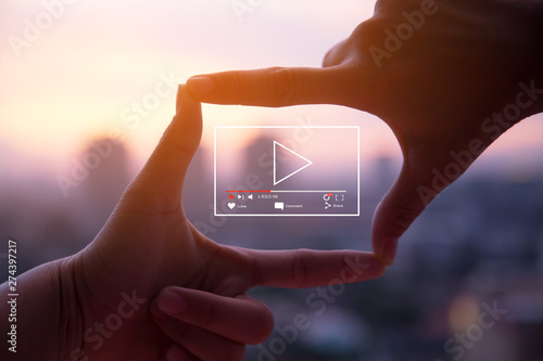Online live video marketing concept.Photo sign made by human hands on blurred sunset sky as background