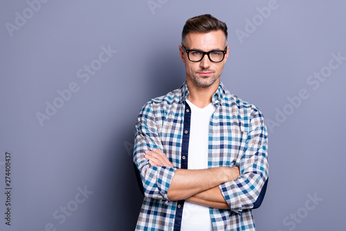 Close up photo handsome he him his guy arms crossed intelligent reliable strict manager financier person not smile self-confident wear specs casual plaid checkered shirt isolated grey background