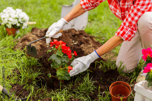 Woman wearing white flowers digging ground after planting flowers