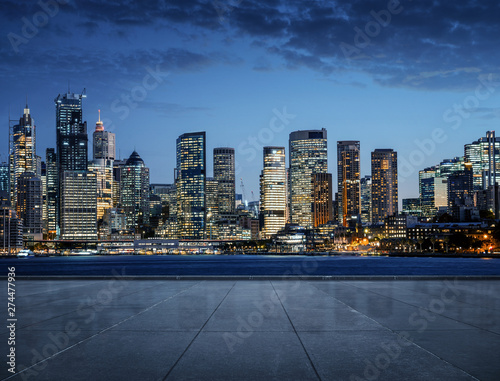 Empty road, sidewalk with the the city at night in the background with copy space 