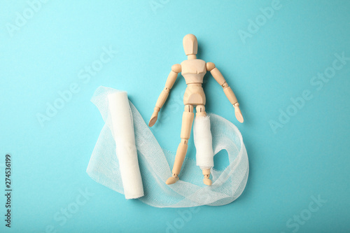 Figure of man with leg wound and white gauze bandage. First aid, injury treatment. Patient in hospital.