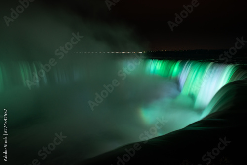 Niagara Falls illuminated in glowing green colours