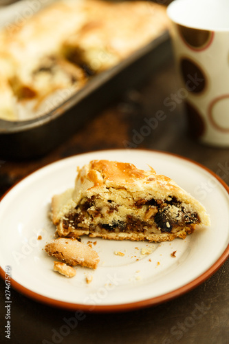 raisin roll with nuts. A piece of cake on a saucer