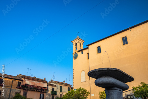 The Convent of S. Maria delle Grazie, in Santa Maria square. The bell tower with the clock. The blue sky at sunset. Roman stone fountain in the foreground. Zagarolo, Province of Rome, Lazio, Italy