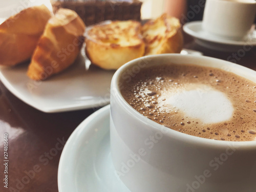 Brazilian breakfast. Capuccino cup and toasted bread with butter background.