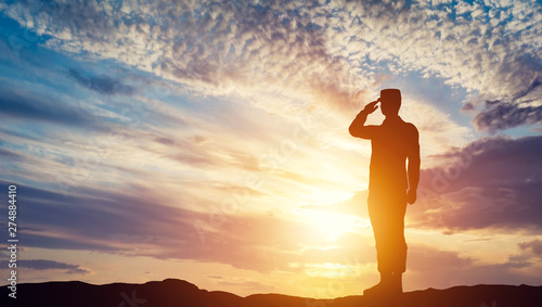 Soldier saluting at sunset. Army, salute, patriotic concept.