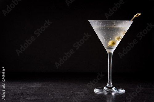 Classic Dry Martini with olives on black background. Copyspace