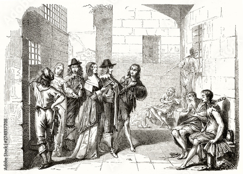 Ancient aristocratic men visiting the interior of a shabby prison and its poor chained prisoners. Old etching style 19th century illustration by Bosse publ. on Magasin Pittoresque Paris 1848