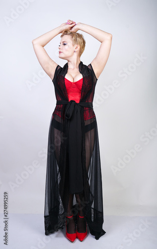 hot curvy plus size female in red black lingerie posing isolated on white studio background alone