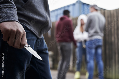 Close Up Of Teenage Boy In Urban Gang Holding Knife